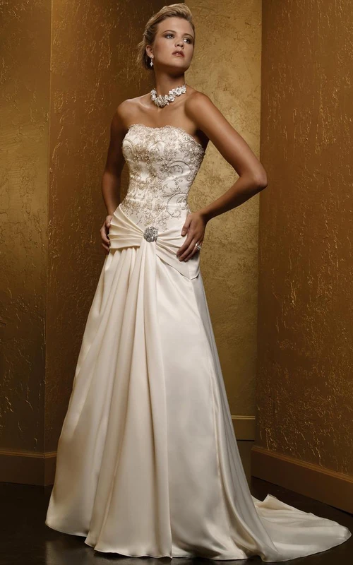 Robe de mariée bustier en satin, coupe trapèze, sans manches, ornée de perles, avec broche et laçage au dos.