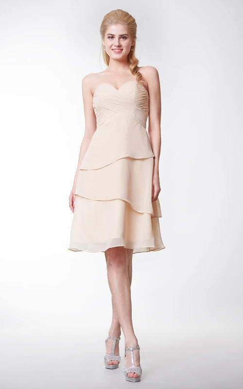 Vestido sencillo de gasa con escote corazón, corte en A y largo hasta la rodilla con capas.