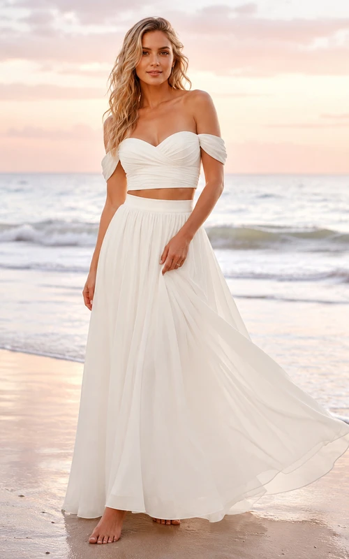 Conjunto nupcial para playa con falda de gasa fruncida y hombros descubiertos al atardecer.