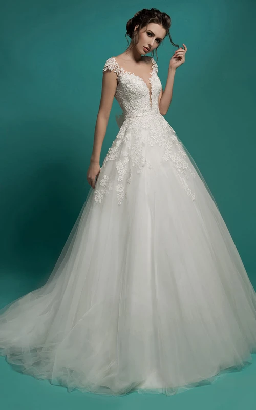 Vestido largo de tul con escote en V, manga corta y corte en A, con apliques y lazo.