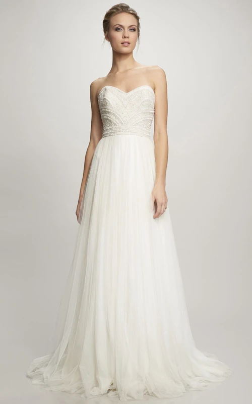 Vestido de novia largo de tul con escote corazón, corte en A, con pedrería y cremallera.