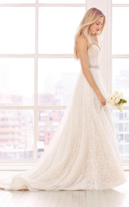 Magnífico vestido de encaje con escote corazón y cintura adornada con cuentas.