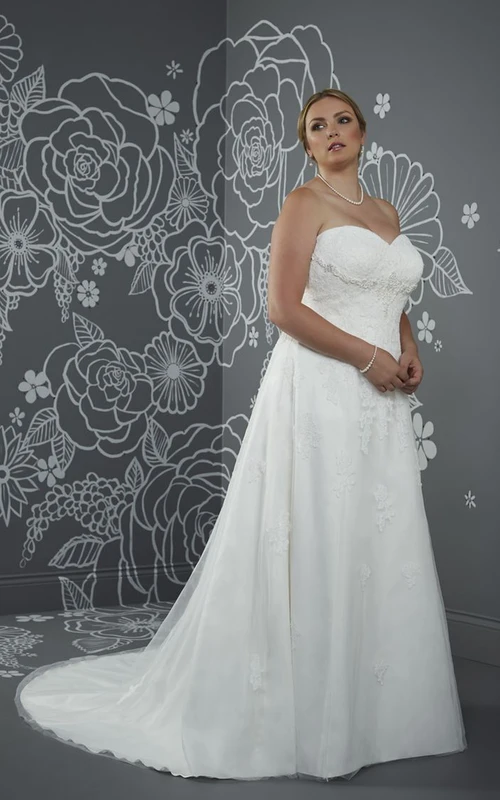 Robe trapèze longue sans manches en satin avec décolleté cœur, traîne courte et laçage au dos ornée de perles