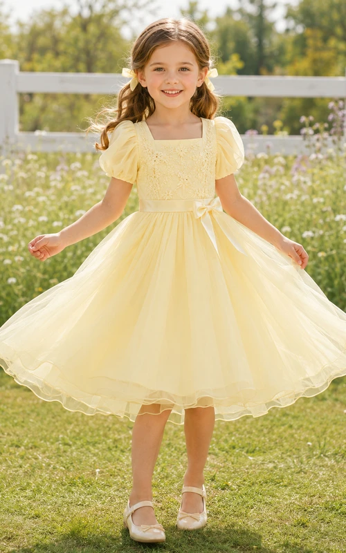 Robe de demoiselle d'honneur jaune beurre en tulle, coupe trapèze, manches bouffantes, col carré et volants