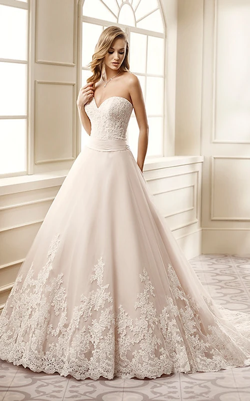 Robe de mariée longue en dentelle, coupe trapèze, décolleté cœur, ornée d'appliques et dos corset.