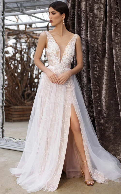 Robe de mariée vaporeuse de plage, décolletée, sans manches, fendue sur le devant, en tulle et dentelle, dos nu, ornée d'appliqués. Robe de mariée vaporeuse à dos nu et décolleté plongeant, sans manches, en tulle et dentelle.