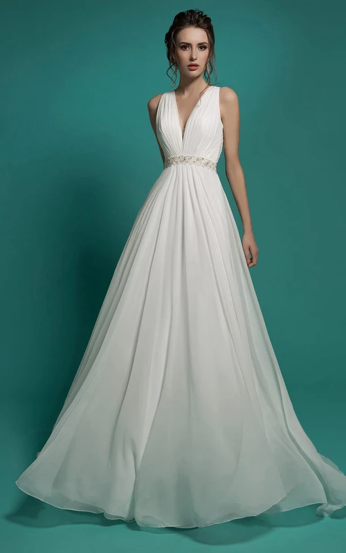 Robe longue trapèze en mousseline de soie à col en V sans manches, coupe empire, ornée de perles et de fronces, avec décolleté en V et ourlet illusion.