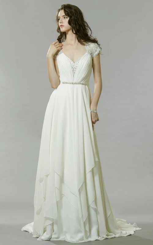 Robe de mariée longue en mousseline ornée de perles et de bijoux, col en V, traîne et décolleté en goutte d'eau.