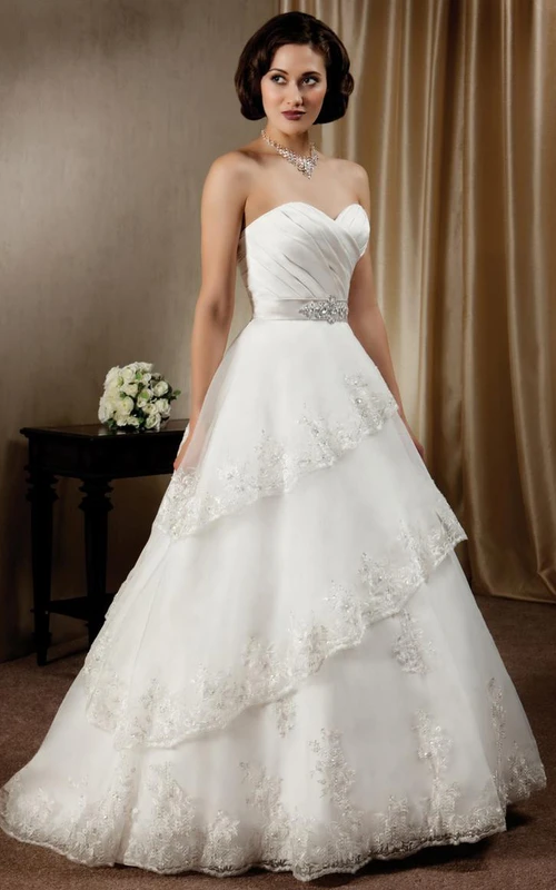 Vestido de novia de satén largo hasta el suelo con escote corazón cruzado, falda en línea A, volantes y joyas en la cintura.