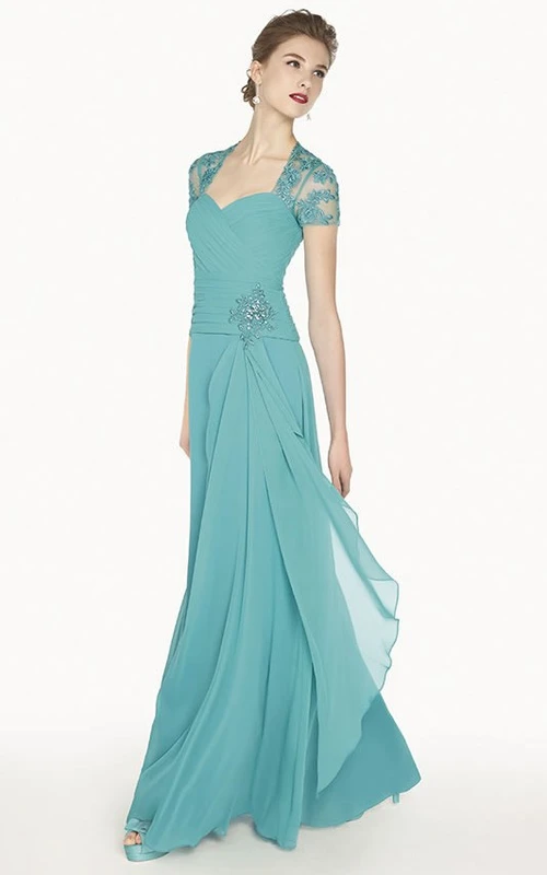 Robe de bal longue en mousseline de soie, coupe trapèze, style reine Anne, ornée d'appliques et d'un dos illusion.