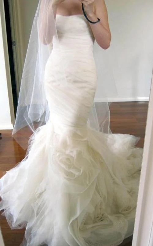 Vestido de novia de sirena color marfil con escote corazón y cola escalonada, fruncido.