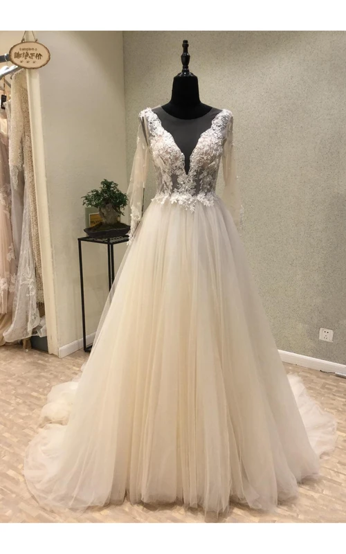 Elegante vestido de novia de corte A largo hasta el suelo con escote pronunciado, espalda en V profunda y tul, ideal para la recepción.