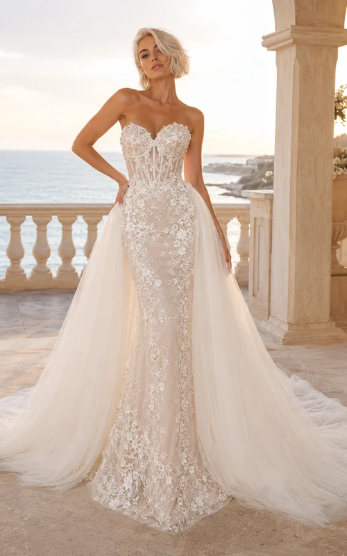 Robe de mariée sirène bustier en dentelle et tulle lumineux, décolleté cœur, traîne cathédrale et jupe amovible, idéale pour un mariage à destination.