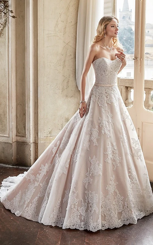 Robe de mariée en dentelle, décolleté cœur et traîne courte, style princesse.