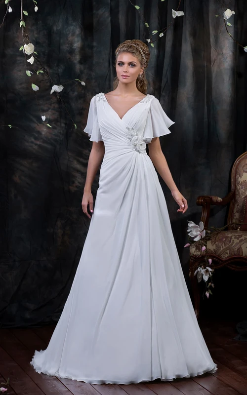 Vestido de gasa largo hasta el suelo con escote en V, mangas de poeta, espalda tipo corsé, drapeado lateral y flor.