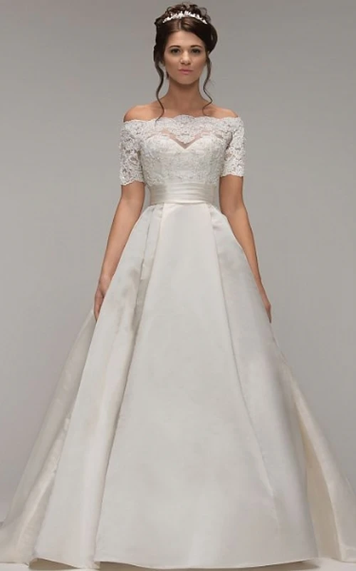 Robe de mariée en satin à manches courtes et épaules dénudées, coupe trapèze, avec effet illusion.
