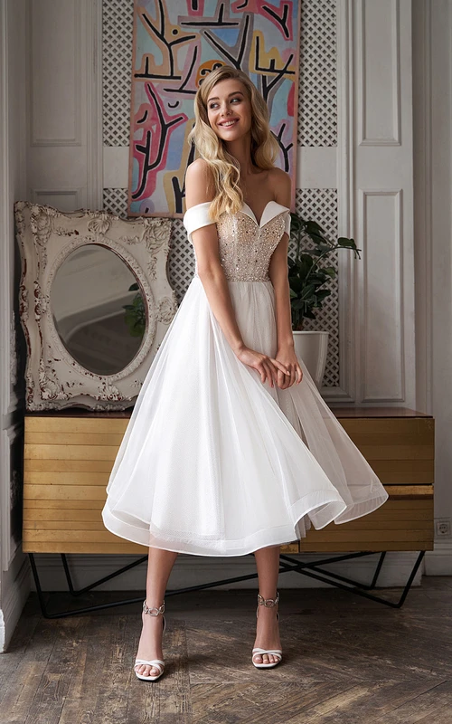 Elegante vestido de novia de corte A con corpiño de hombros descubiertos y detalles de cuentas, largo hasta la rodilla.