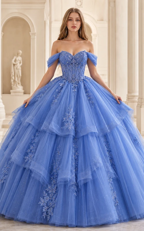 Vestido de baile dramático de quinceañera con escote corazón y hombros descubiertos en azul real y falda de tul en cascada.