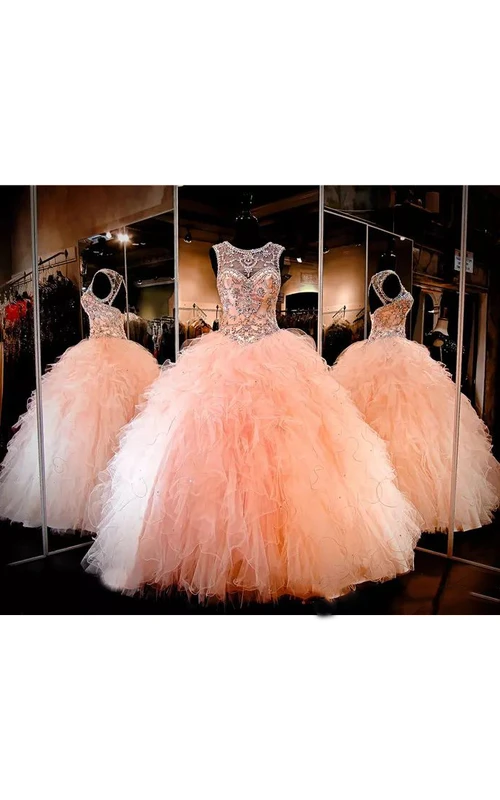 Robe de bal longue sans manches en tulle avec dos lacé et décolleté en forme de goutte.