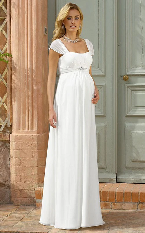Vestido de novia de gasa con escote cuadrado y mangas cortas, corte imperio y detalles de pedrería.