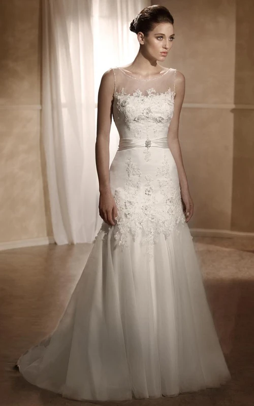 Robe de mariée trapèze longue sans manches en tulle et satin appliqués, ornée de plis et d'un décolleté en V plongeant dans le dos.
