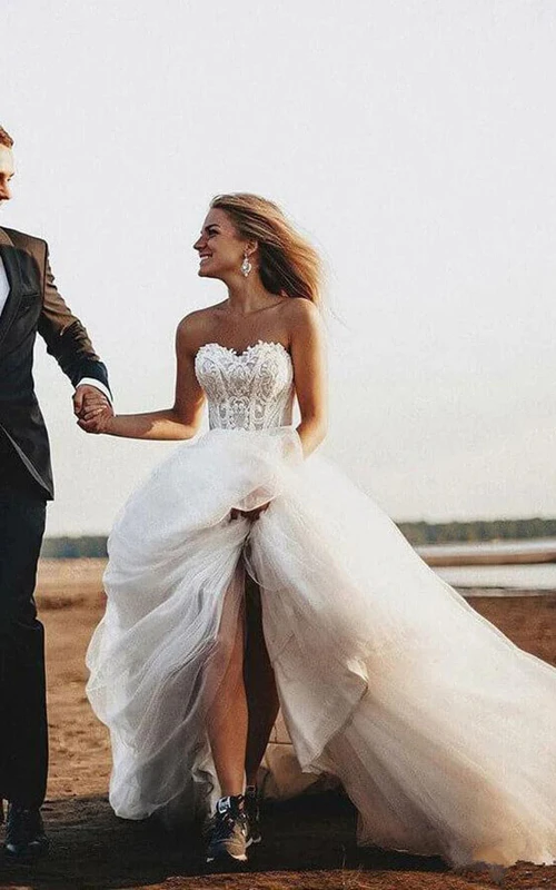 Elegantes A-Linien-Brautkleid aus Tüll mit Schnürung, Spitzenoberteil und kurzer Schleppe für die Strandhochzeit.