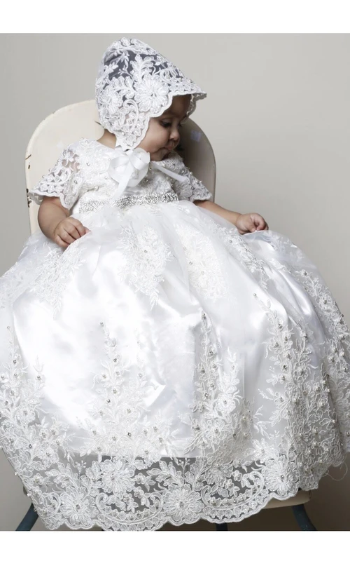 Bezauberndes Taufkleid mit Spitzenapplikationen und Perlengürtel