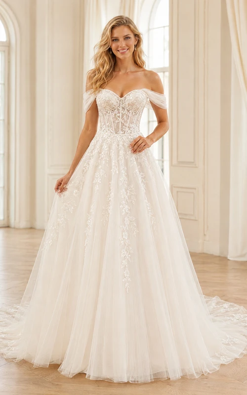 Robe de mariée champêtre en tulle et dentelle aérienne, épaules dénudées, manches courtes, coupe trapèze, traîne chapelle, ornée d'appliqués floraux.