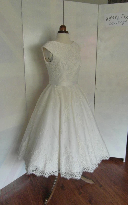 Vestido de encaje de corte A con mangas cortas, largo hasta la rodilla, espalda en V y fajín de satén.