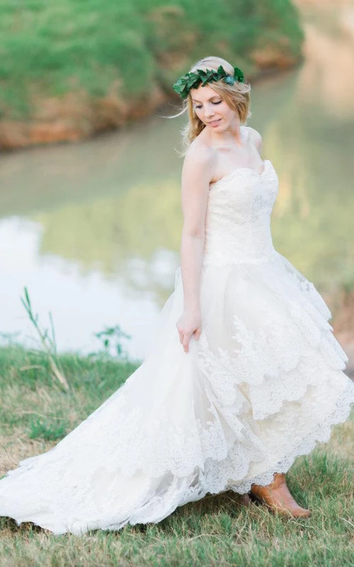 Robe de mariée Guenièvre à ourlet asymétrique en dentelle, idéale pour un mariage champêtre à la campagne.