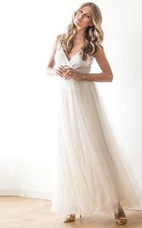 Robe en tulle à fines bretelles, col en V, coupe trapèze, longueur cheville, avec ceinture.