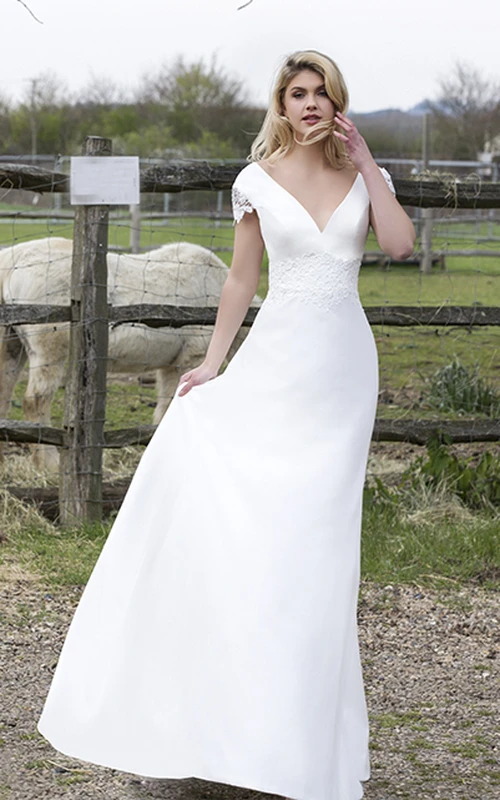 Vestido de novia de satén con escote en V pronunciado, mangas cortas con estampado floral y apliques.