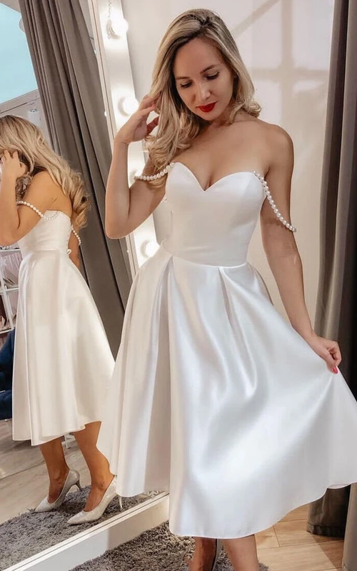 Robe de mariée courte en satin, simple et ornée de perles, avec décolleté en cœur et longueur thé.