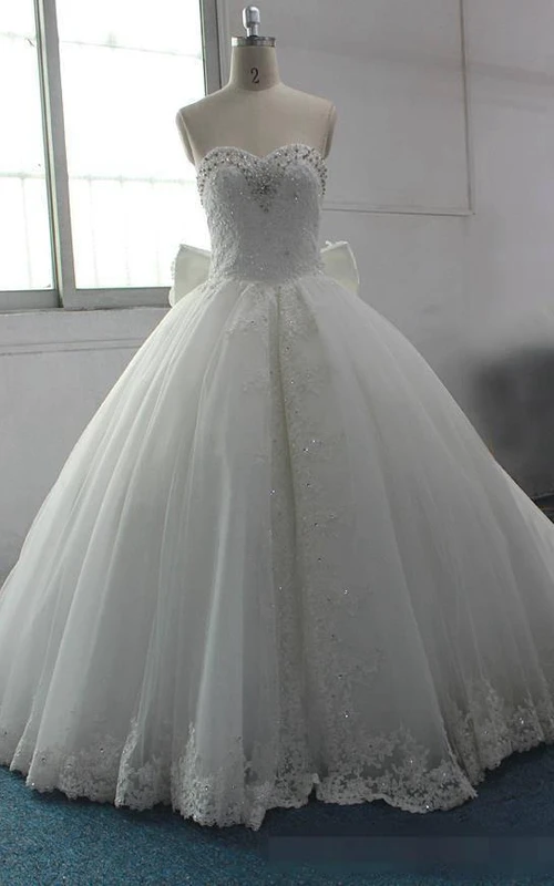 Vestido de gala con lazo, apliques de cuentas, cola de corte, espalda descubierta, cremallera, corsé, gasa, encaje, lentejuelas, organza, satén y tafetán.