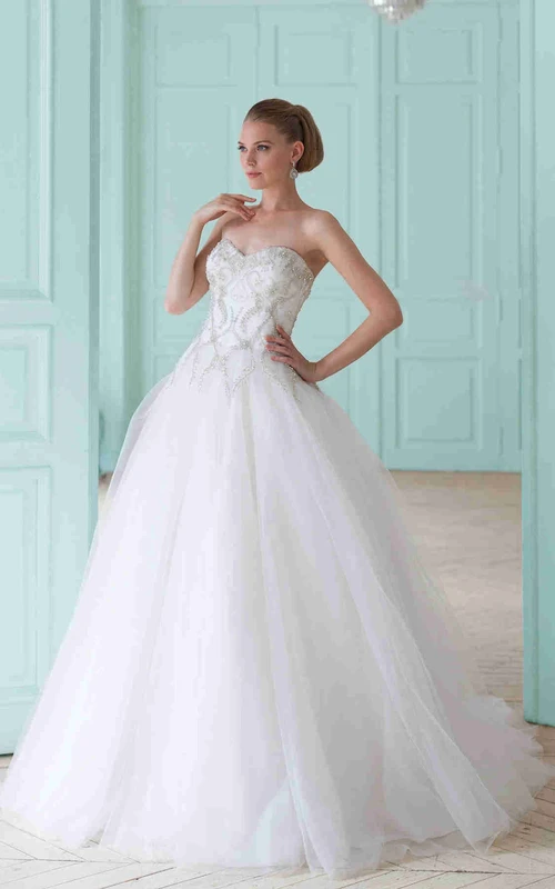 Robe de mariée en tulle à décolleté cœur, ornée de perles et de lacets, style princesse.