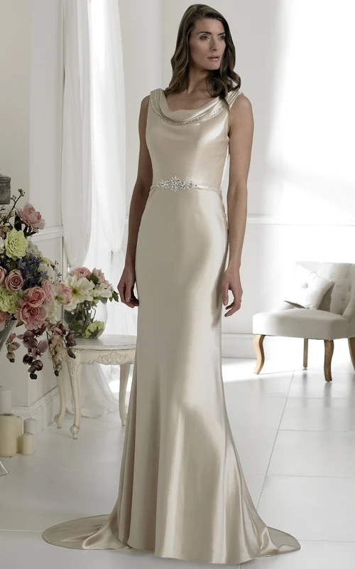 Robe de mariée fourreau sans manches en satin, col bénitier, ornée de bijoux à la taille.