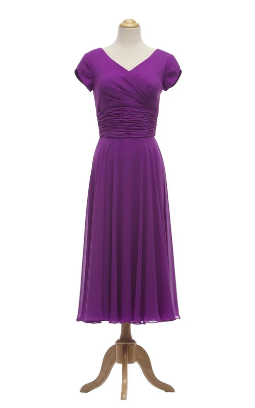 Vestido de manga pétalo con escote en V y largo hasta la rodilla con fruncido en la cintura.