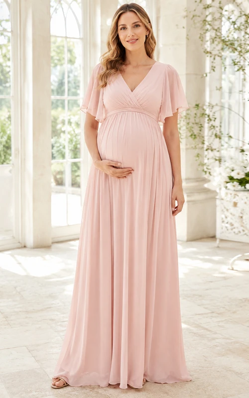 Robe de maternité rose poudré en mousseline rose poudré, col V, manches papillon, longueur empire, col en V.