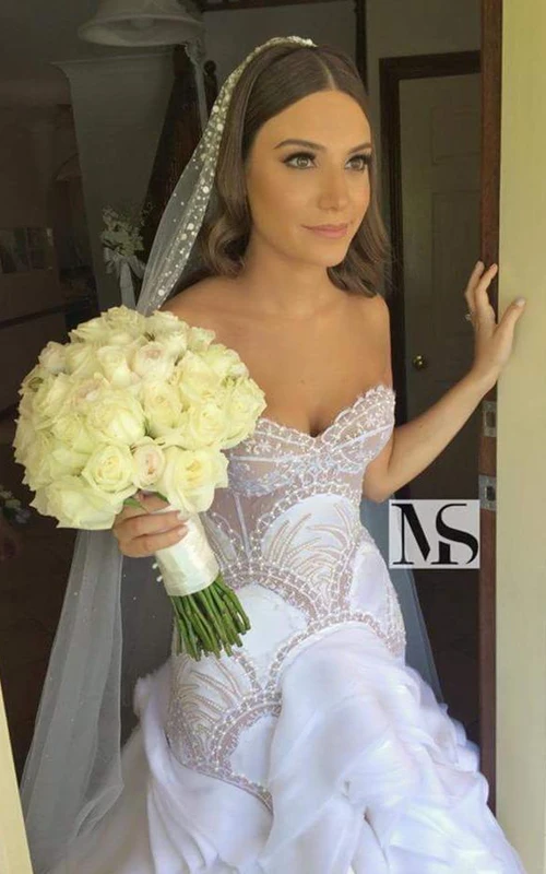 Delicado vestido de novia sin mangas con escote corazón, volantes y detalles de pedrería.