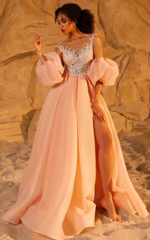 Vestido de fiesta de corte A con escote barco, corte imperio y abertura frontal, con pedrería en la parte superior.
