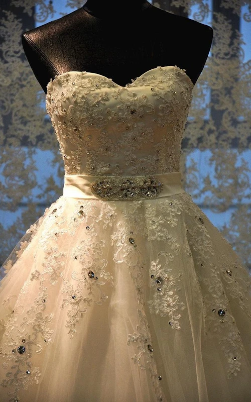 Robe longue trapèze en tulle et dentelle, décolleté cœur orné de perles et d'appliques, dos corset et découpe en forme de goutte