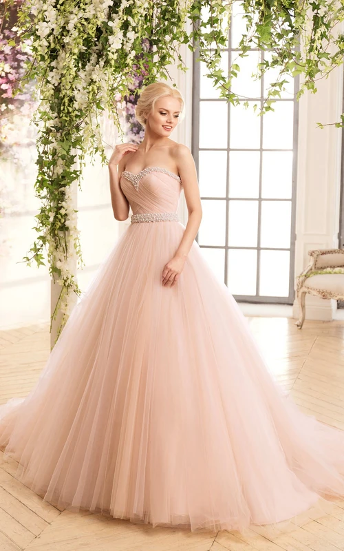 Vestido largo de gala con escote corazón, sin mangas, de tul con cordones, abalorios y tiras cruzadas.