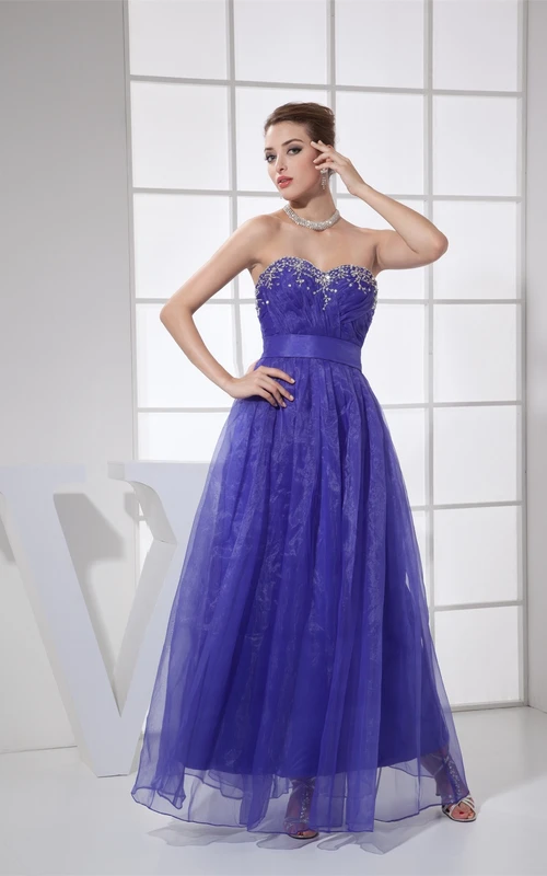 Vestido de corte A con escote corazón, detalles cruzados de cuentas y pliegues.