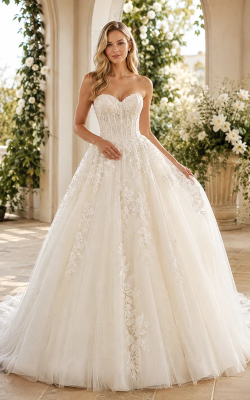 Robe de mariée romantique princesse bustier en tulle orné de dentelle et d'appliqués, avec traîne chapelle.