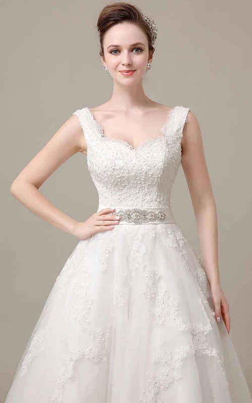 Robe en dentelle sans manches à col en V et coupe trapèze, ornée de perles à la taille.