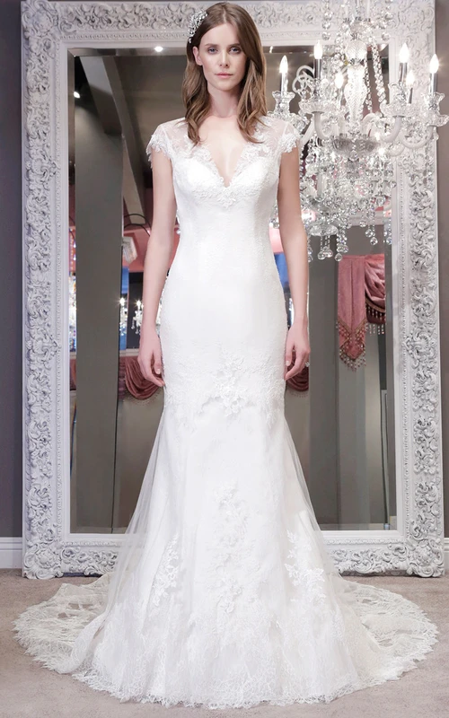 Vestido de novia largo hasta el suelo con escote en V, mangas cortas y encaje, con apliques y efecto ilusión.