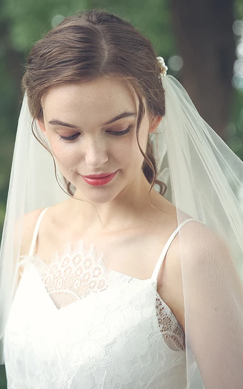 Voile élégant en tulle arrivant aux coudes, orné de perles.