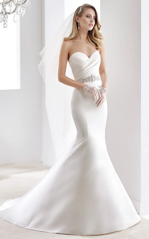 Vestido de novia de satén estilo sirena con escote corazón, corpiño plisado y cinturón de cuentas.
