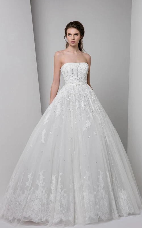 Vestido de novia largo de tul sin mangas, sin tirantes, con apliques, pliegues y pedrería.