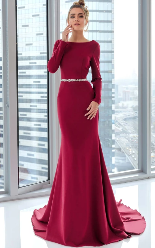 Sencillo vestido de noche de corte imperio con mangas largas transparentes, espalda baja en V, cintura adornada con cuentas y cola.